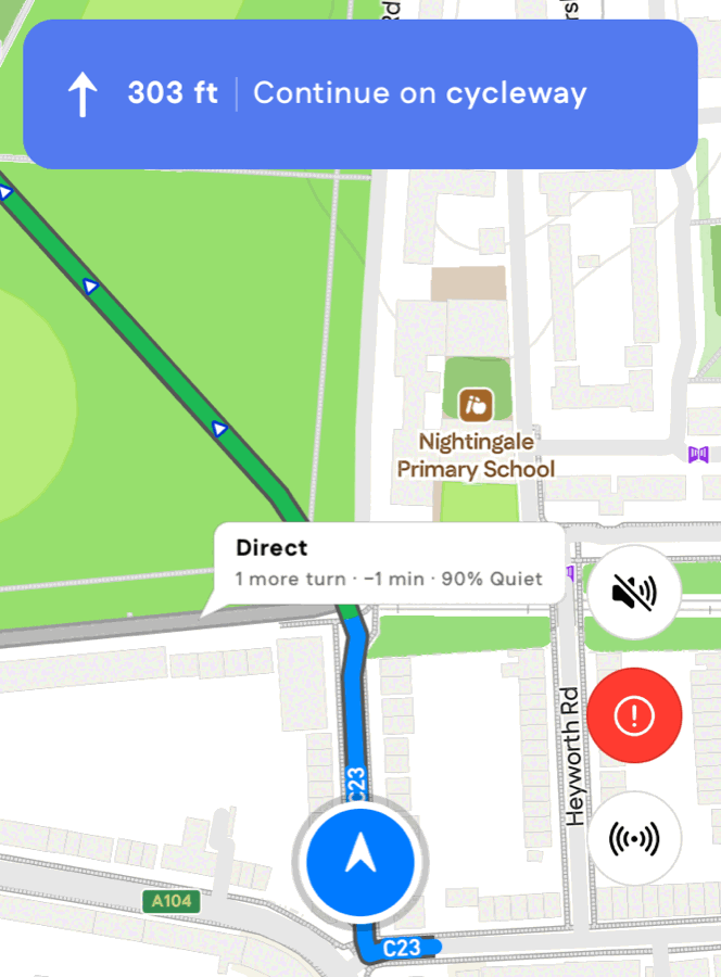 Turn-by-turn navigation approaching a junction, with a white bubble on the alternative route reading "Direct: 1 more turn, 1 minute faster, 90% quiet".