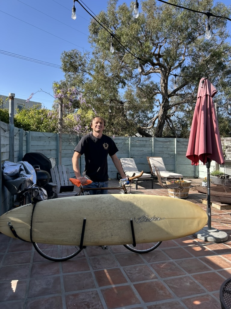 A surfboard on a bike — yet another car trip turned into a bike ride